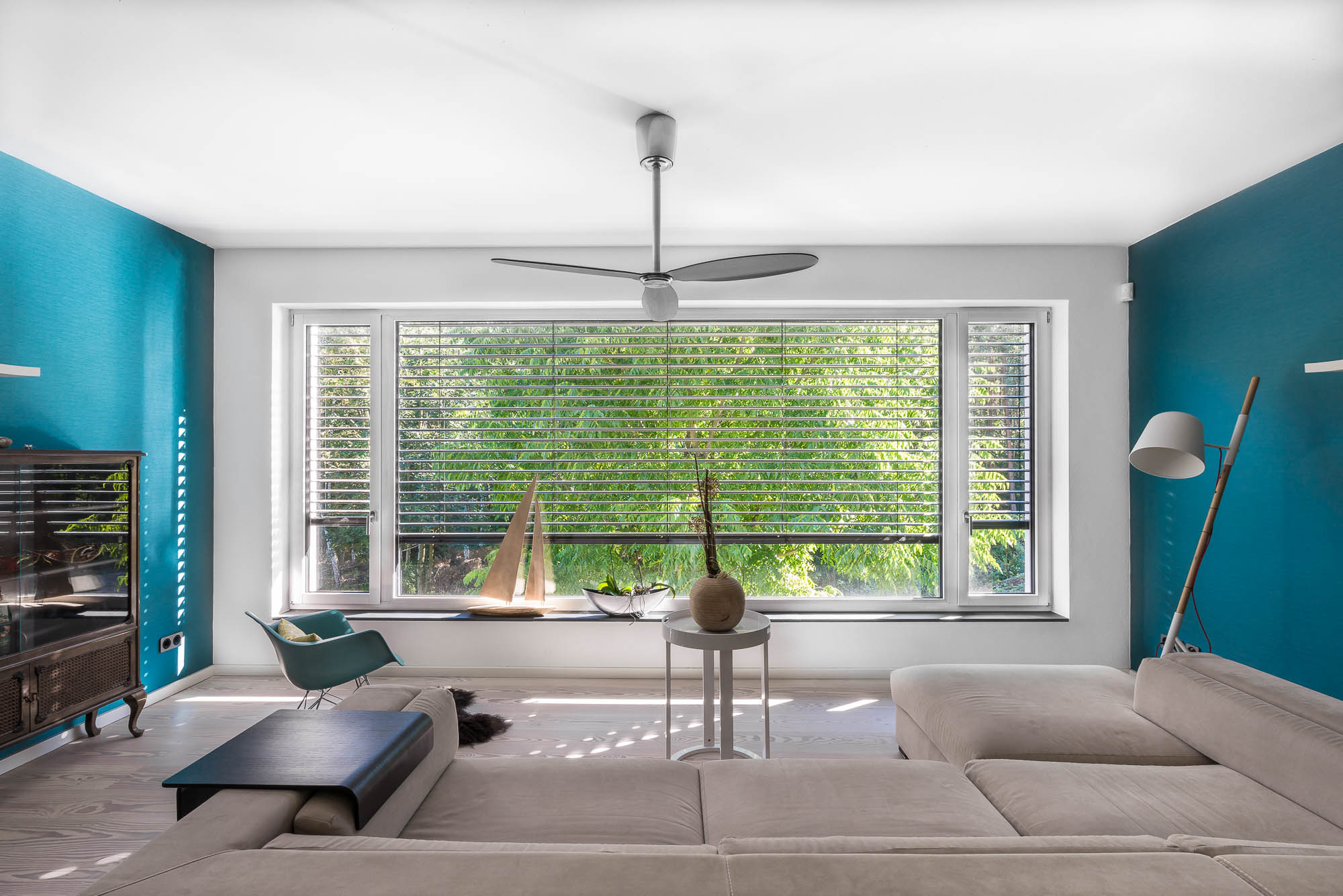 Offenes Wohnzimmer mit Panoramafenster und Designmöbeln