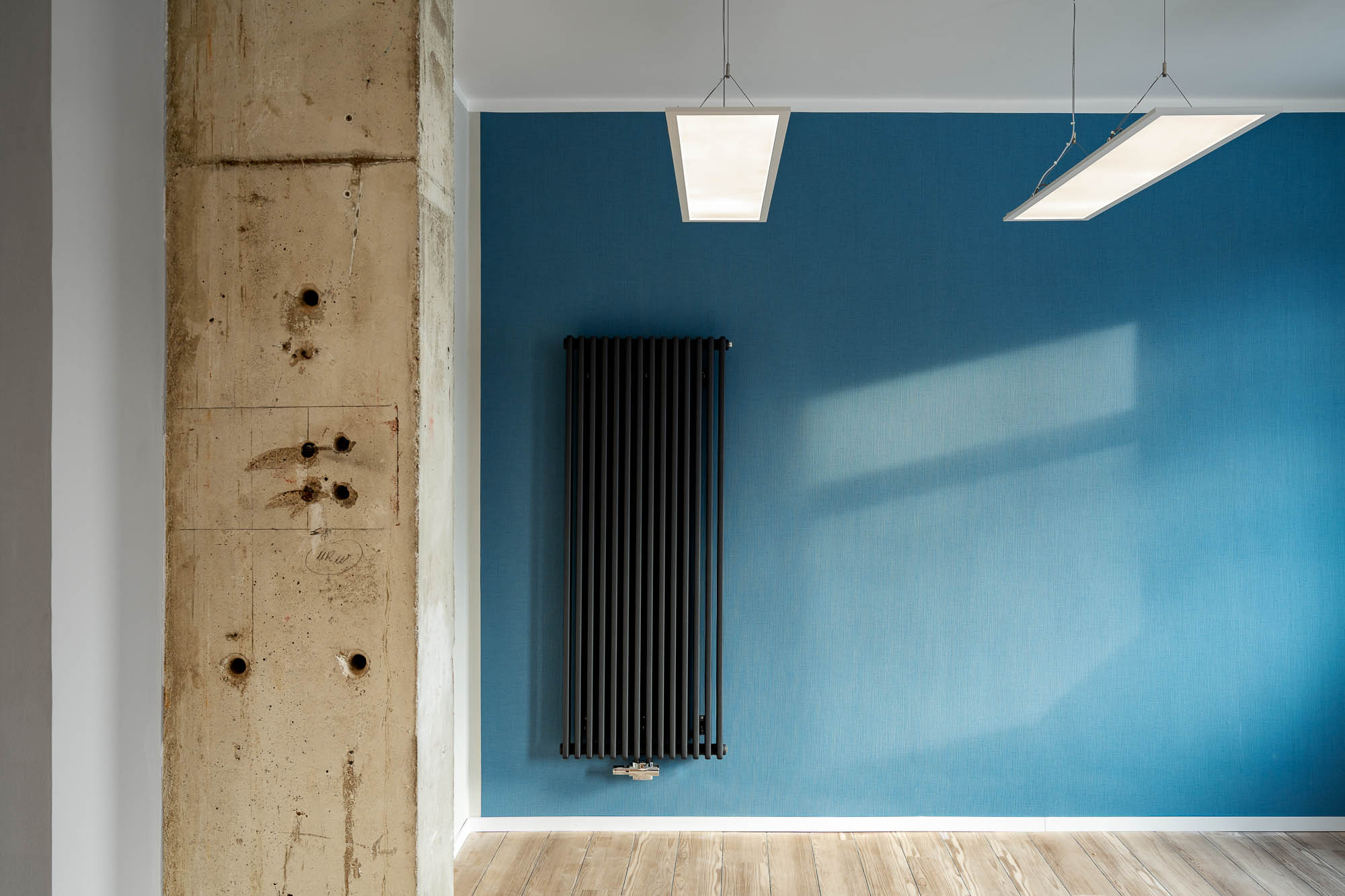 Wanddetail mit vertikalem Heizkörper und Betonstruktur