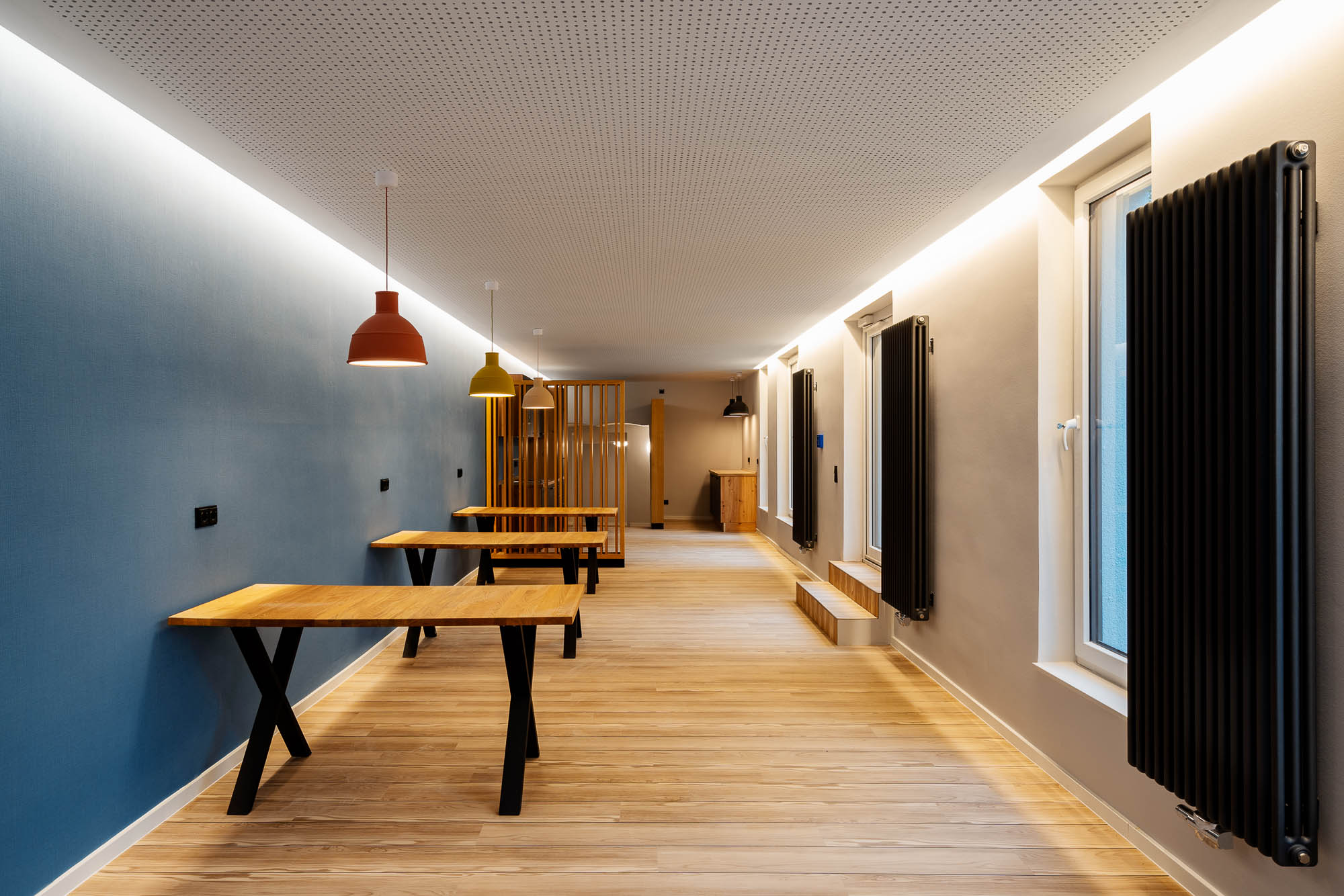Besprechungsraum mit Holztisch und Lichtband an der Decke