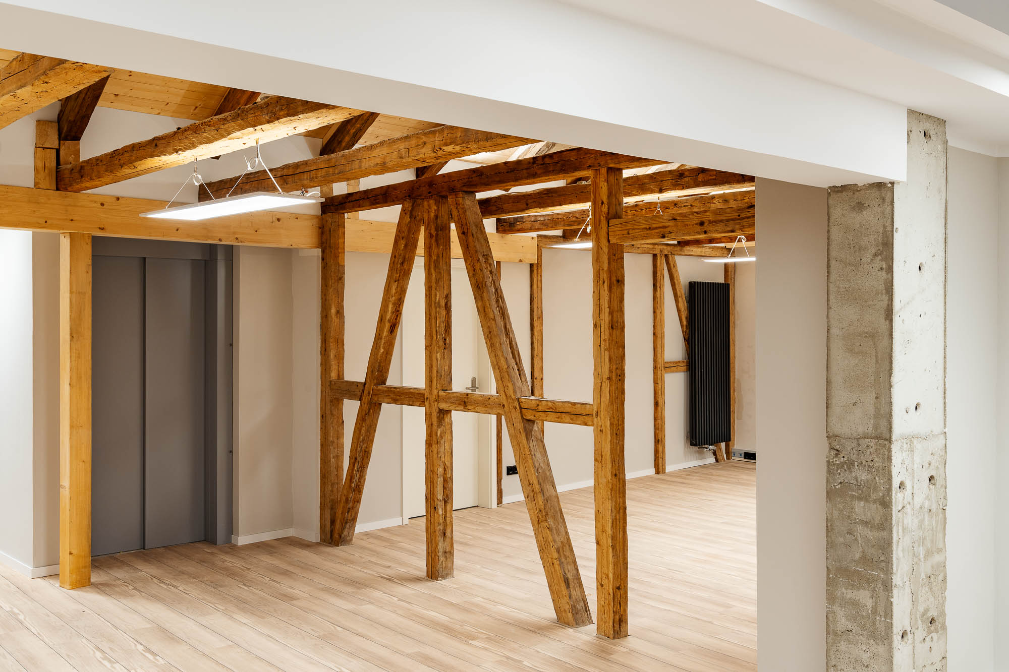 Dachgeschoss mit freiliegenden Holzbalken und weißen Wänden