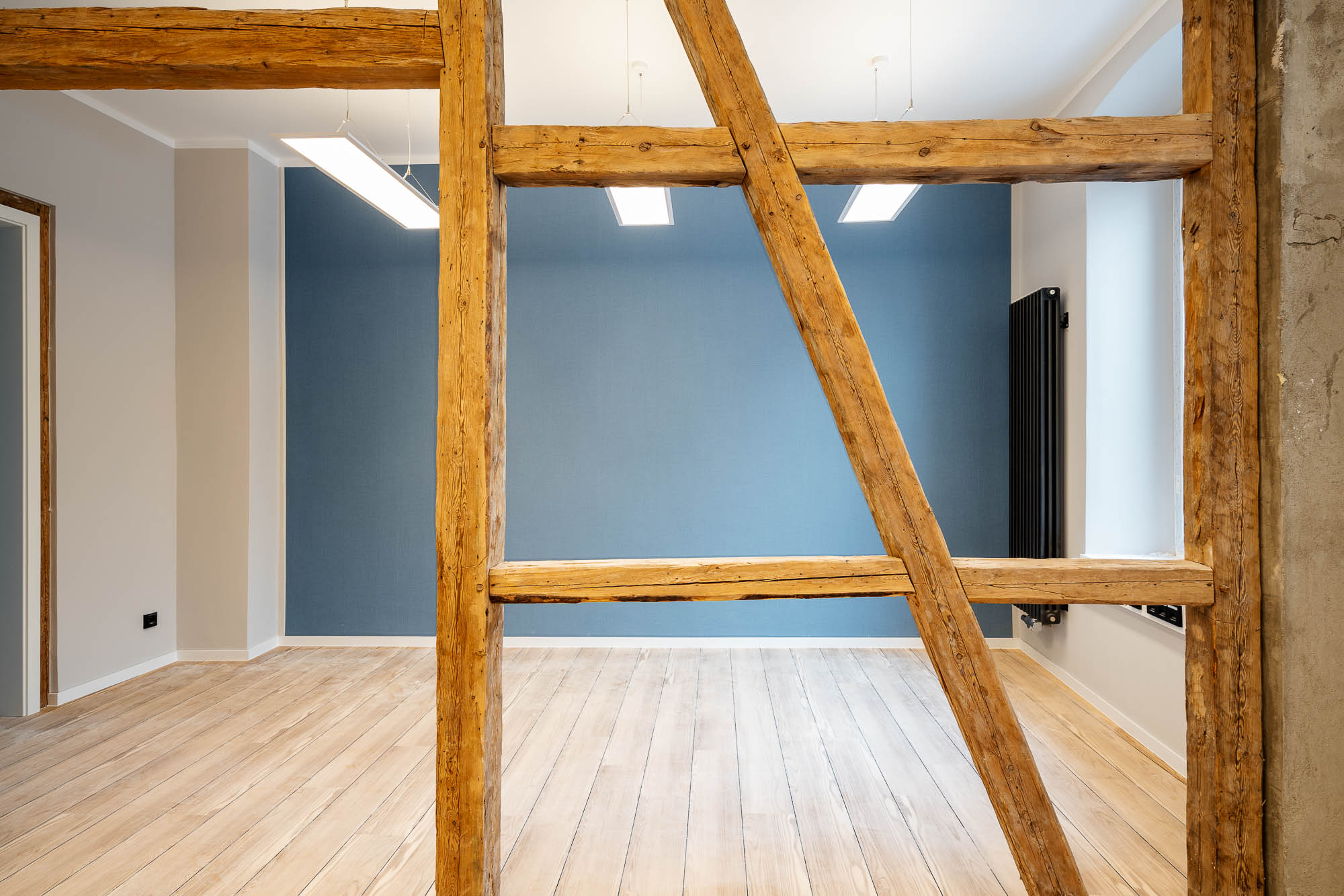 Dachraum mit Holzbalken und blauer Wandgestaltung