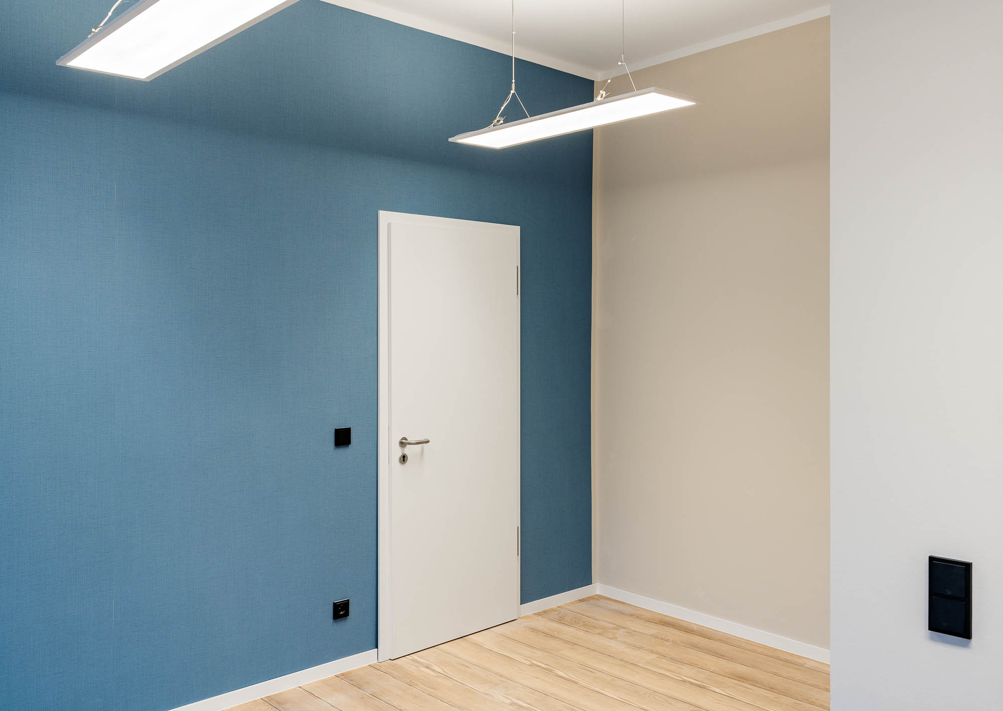Flur mit blau gestrichener Wand und weißen Türen