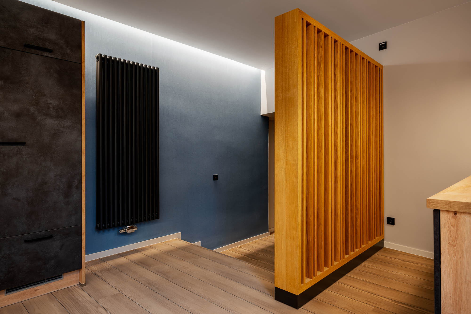 Detailansicht mit dunkler Wandverkleidung und Holztür