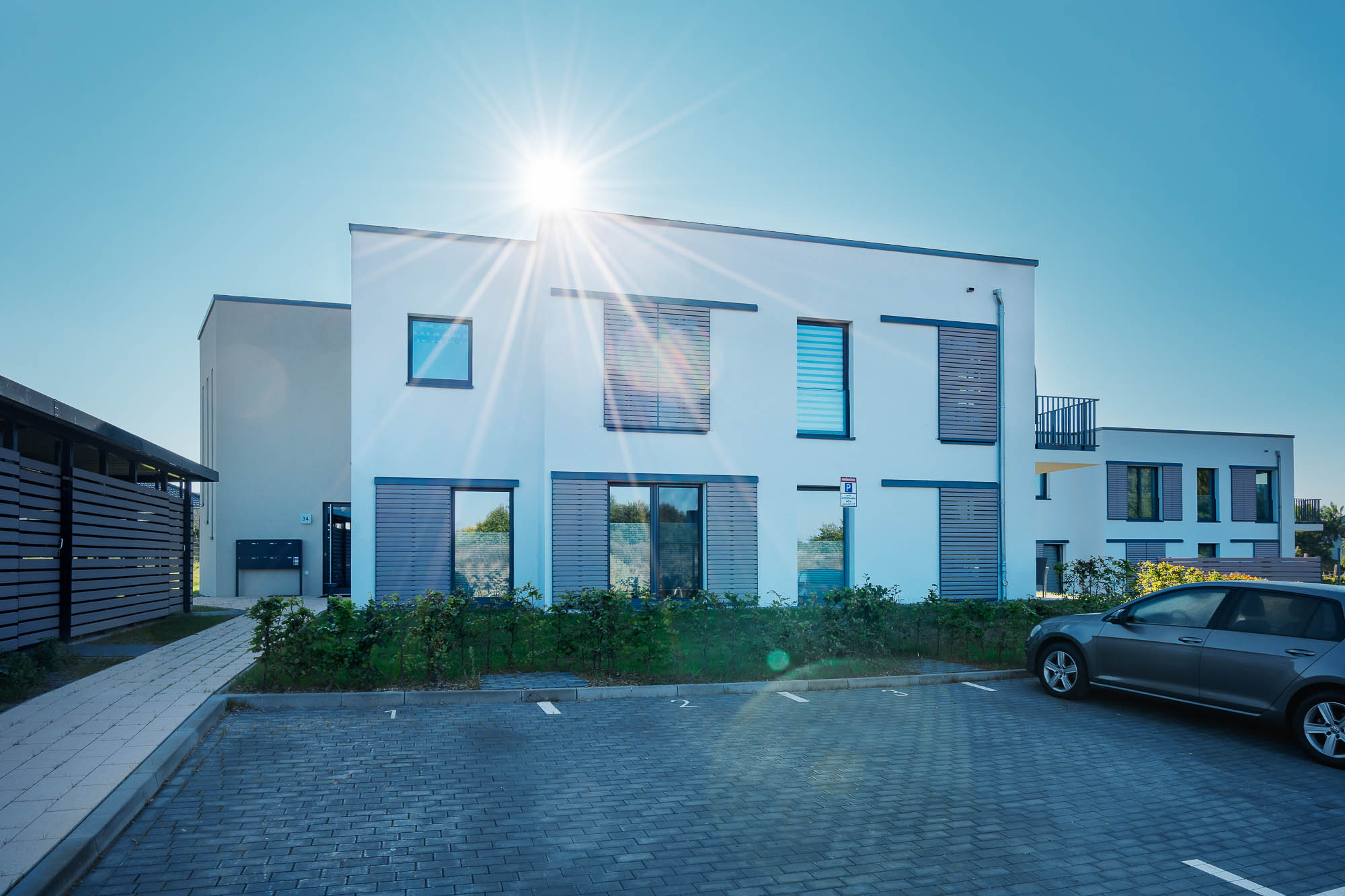 Neubau eines Mehrfamilienhauses mit Einfahrt und Sonnenschein