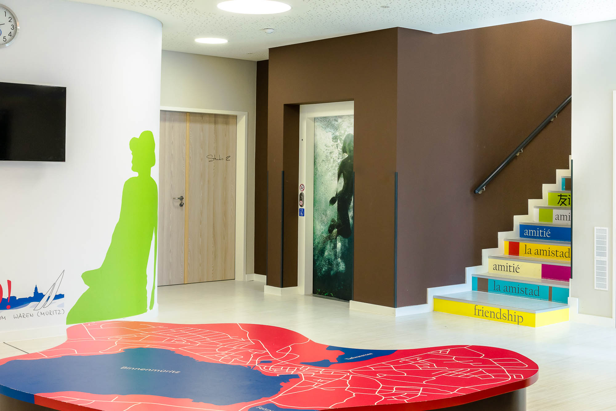 Eingangsbereich mit bunter Wandgestaltung und Treppe