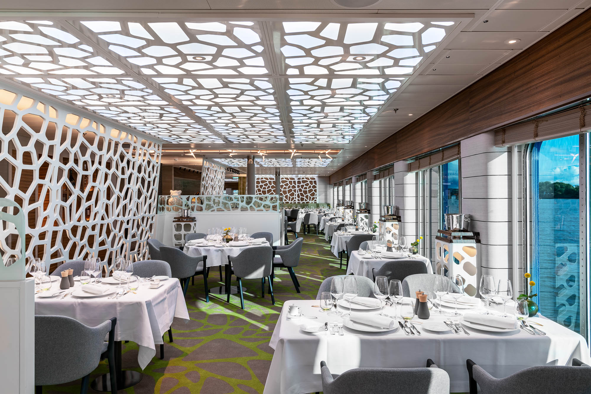 Restaurant mit hellem Deckendesign und Panoramafenstern auf der HANSEATIC Inspiration