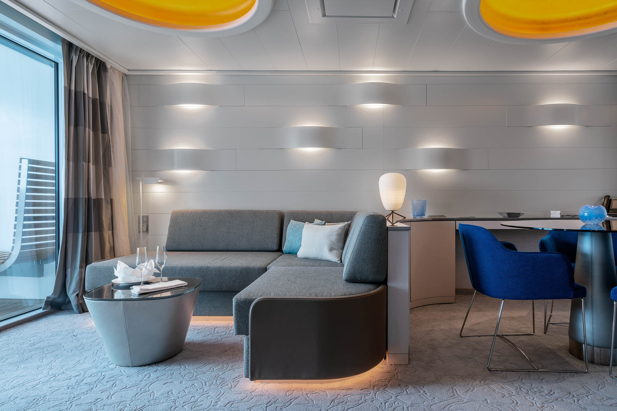 Lounge mit Sofas und modernen Lichtakzenten auf der HANSEATIC Inspiration