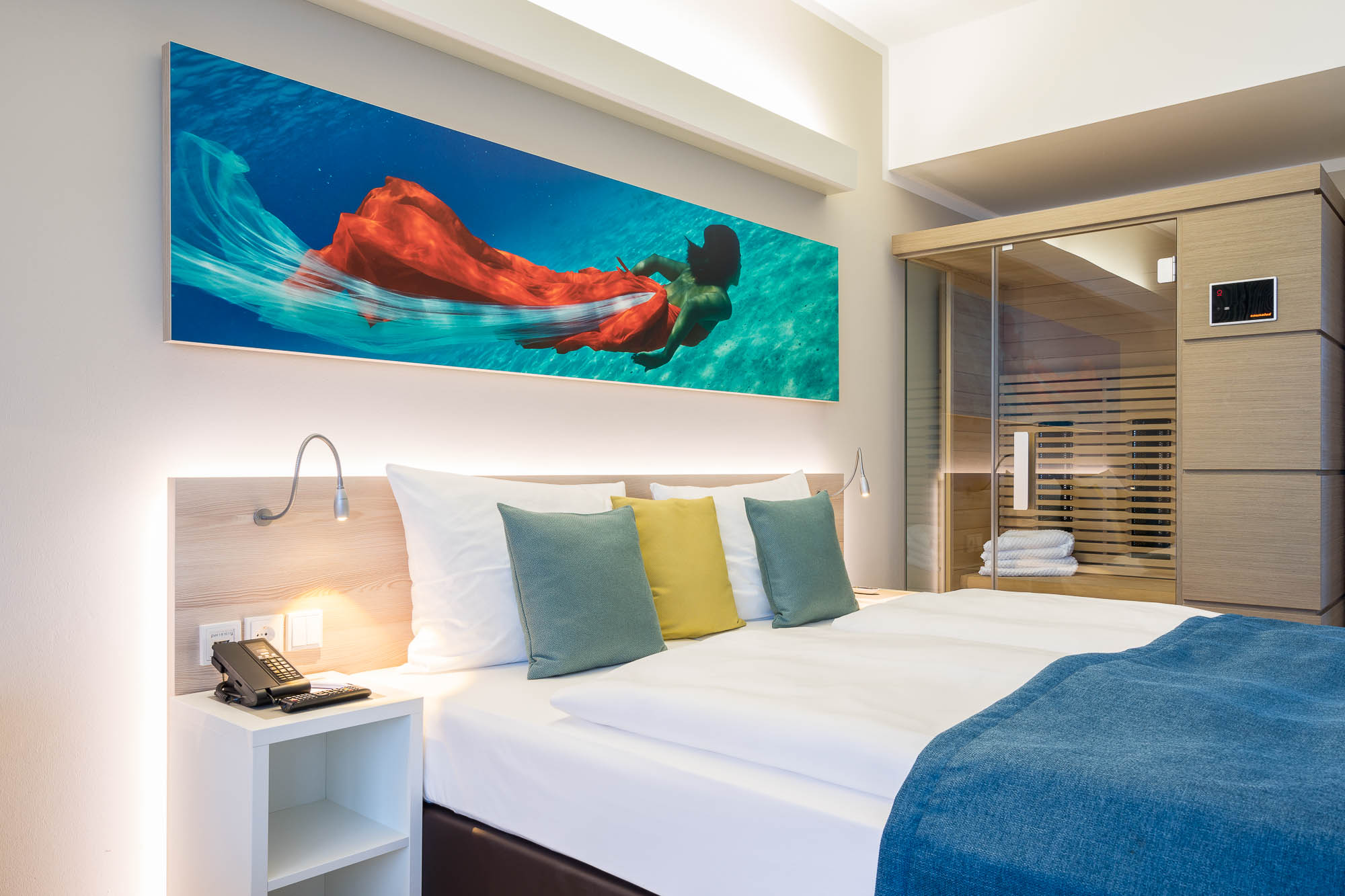 Hotelzimmer mit Doppelbett und maritimer Wandgestaltung