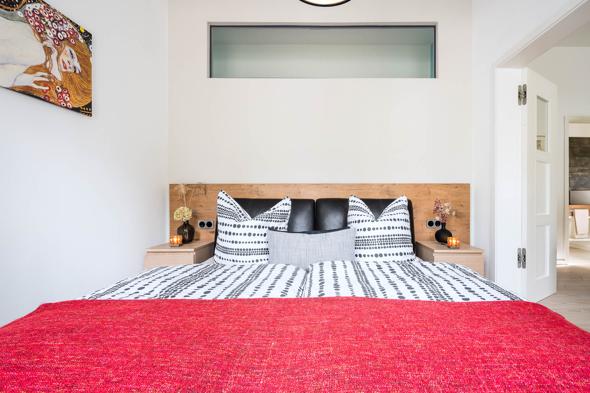 Schlafzimmer mit Doppelbett und roter Decke