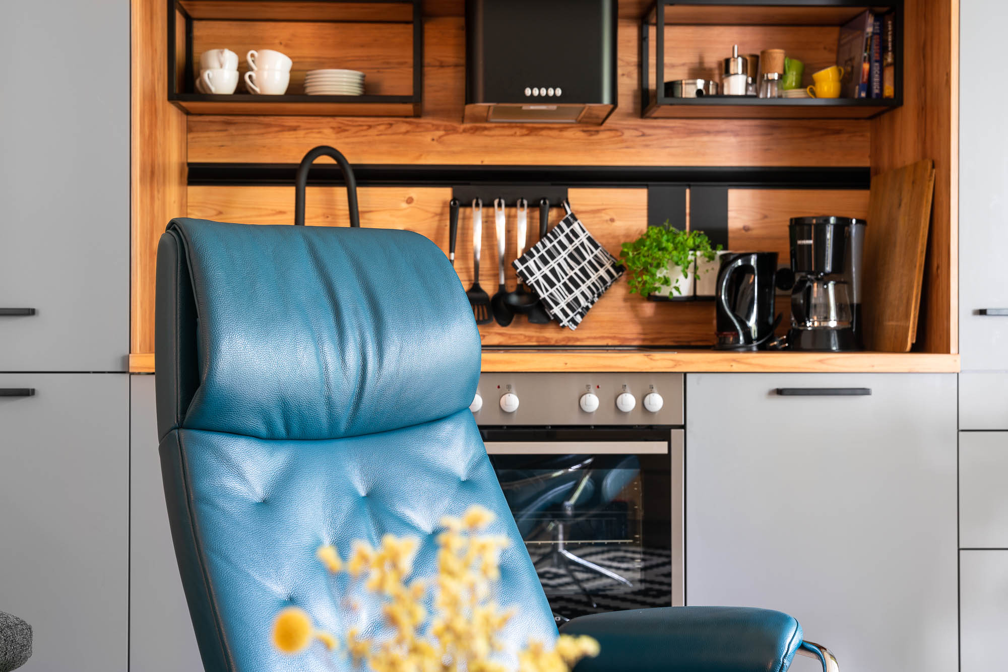 Detailaufnahme von Küche und blauem Sessel