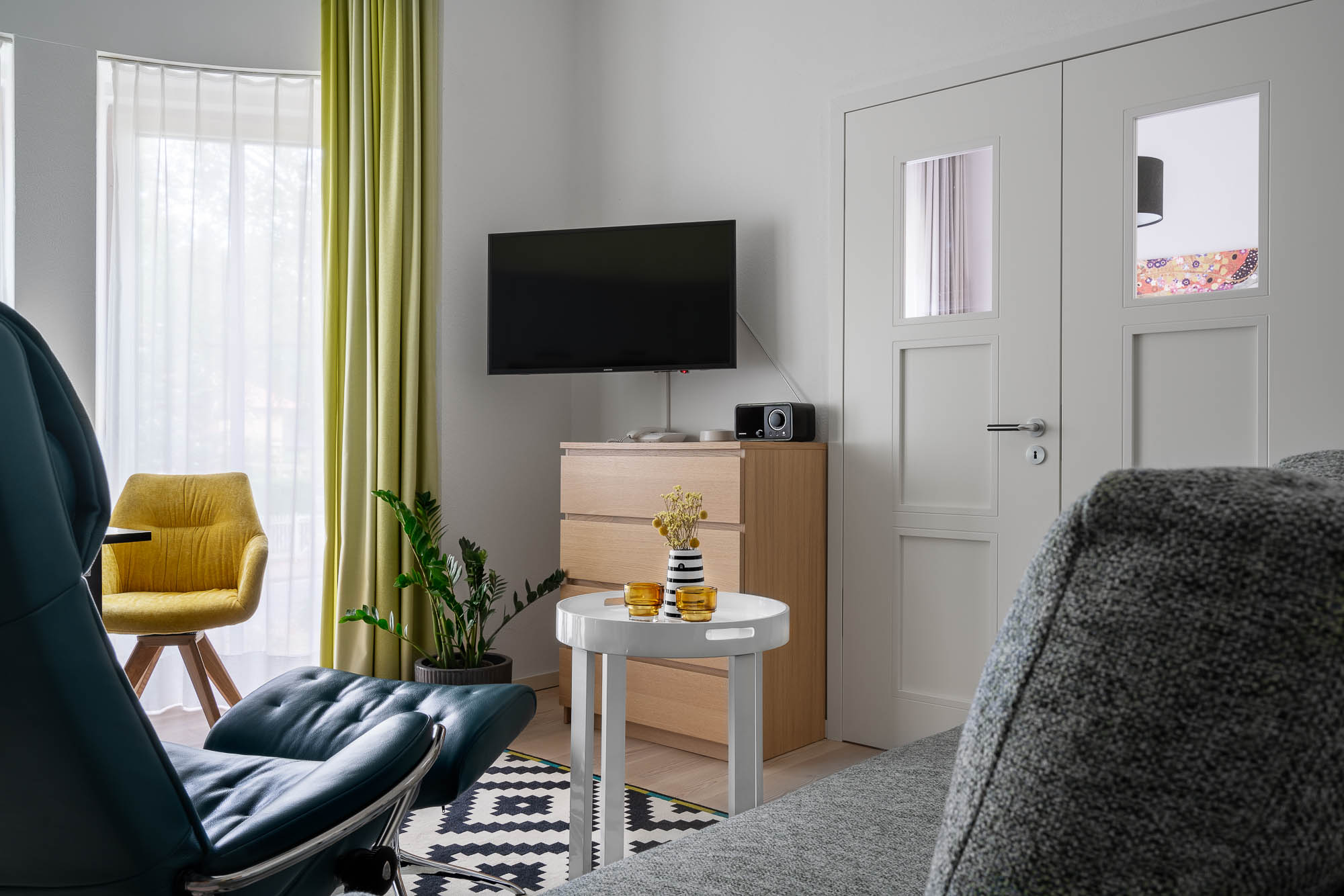 Heller Wohnbereich mit Fernseher und Sitzgruppe