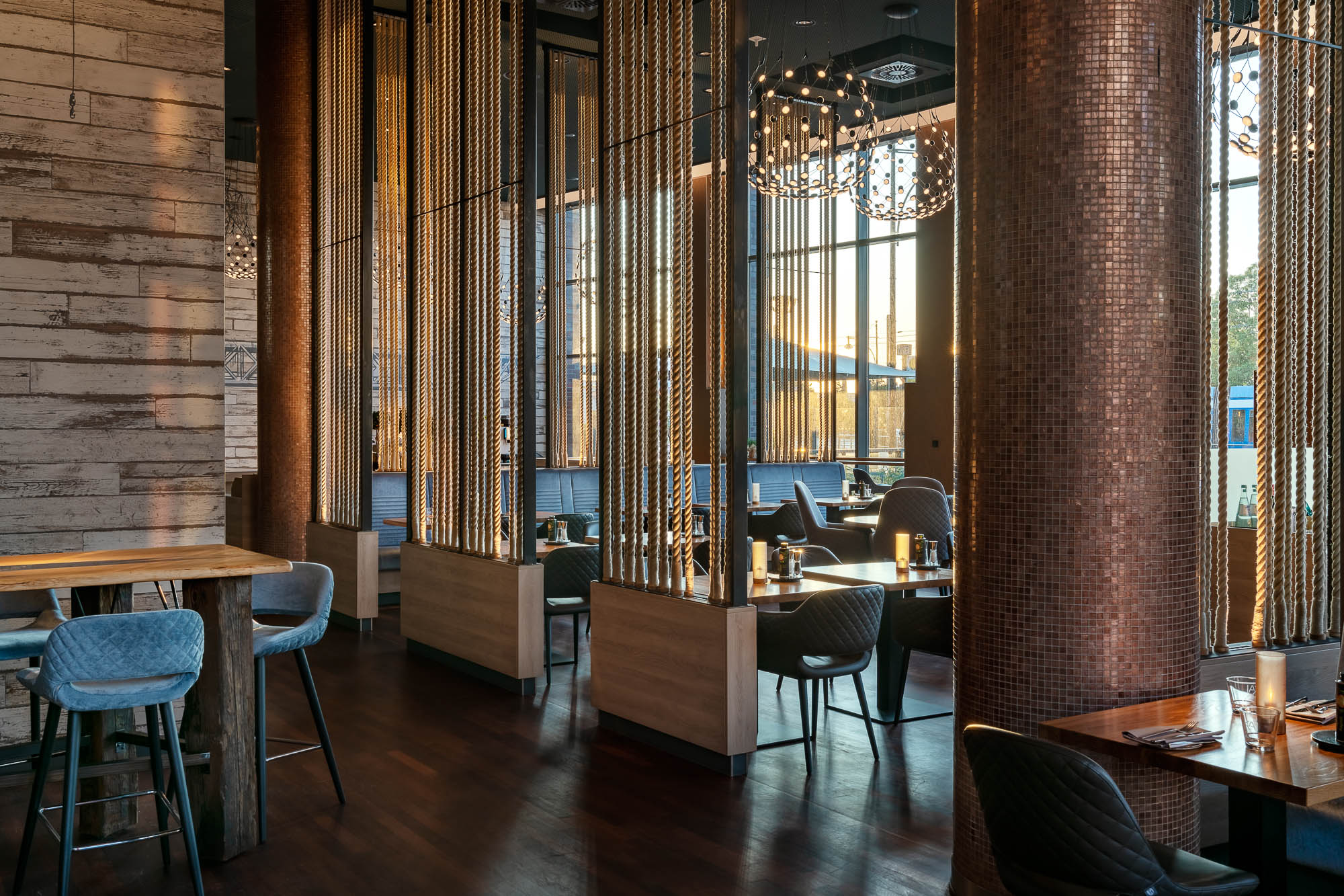 Restaurantbereich mit dunklen Holztischen und Säulen