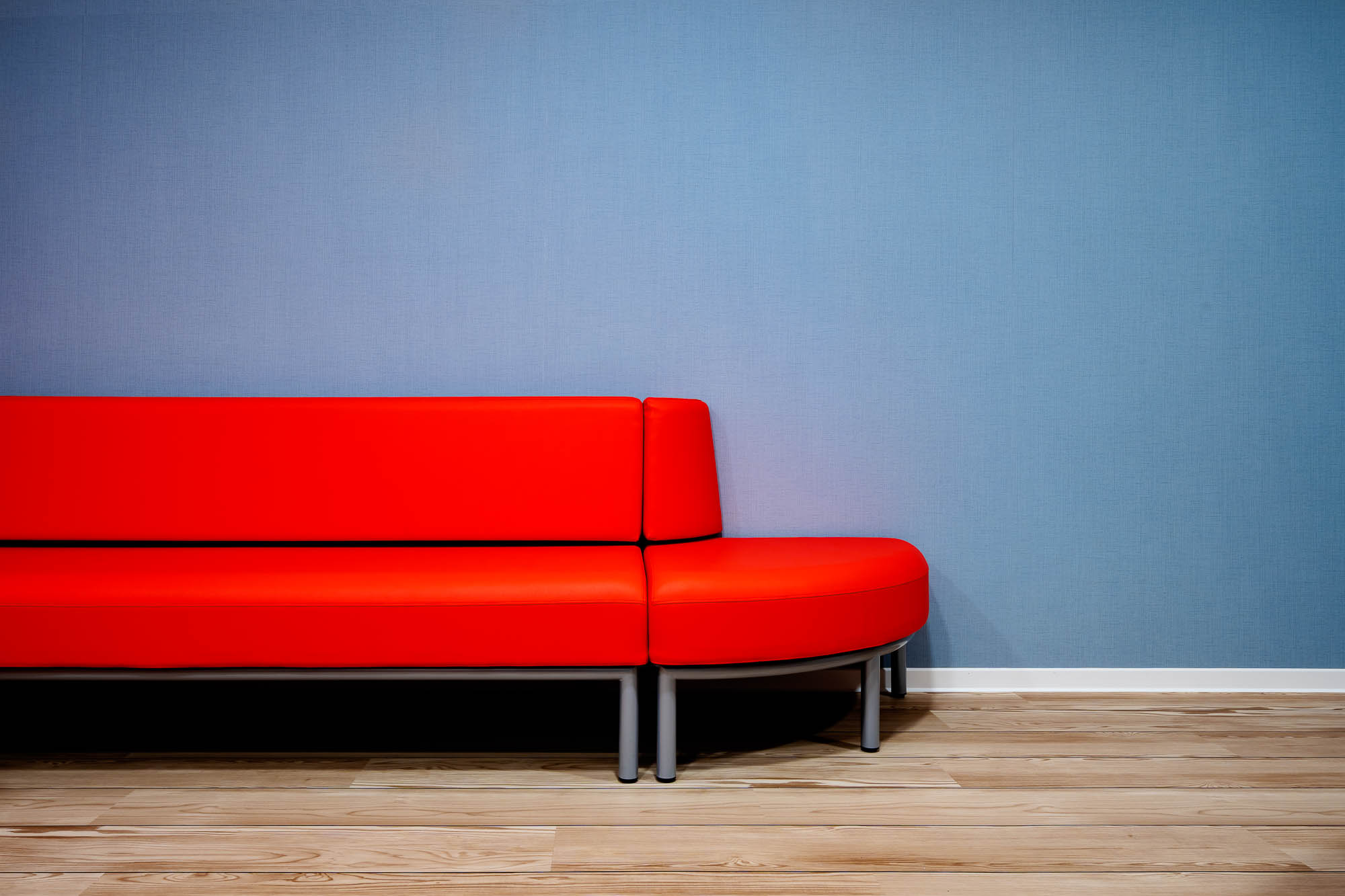 Wartebereich mit rotem Sofa als Farbakzent