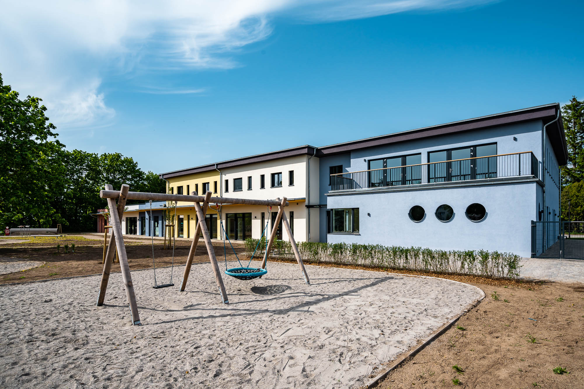Kita-Außenbereich mit Spielplatz und Schaukeln
