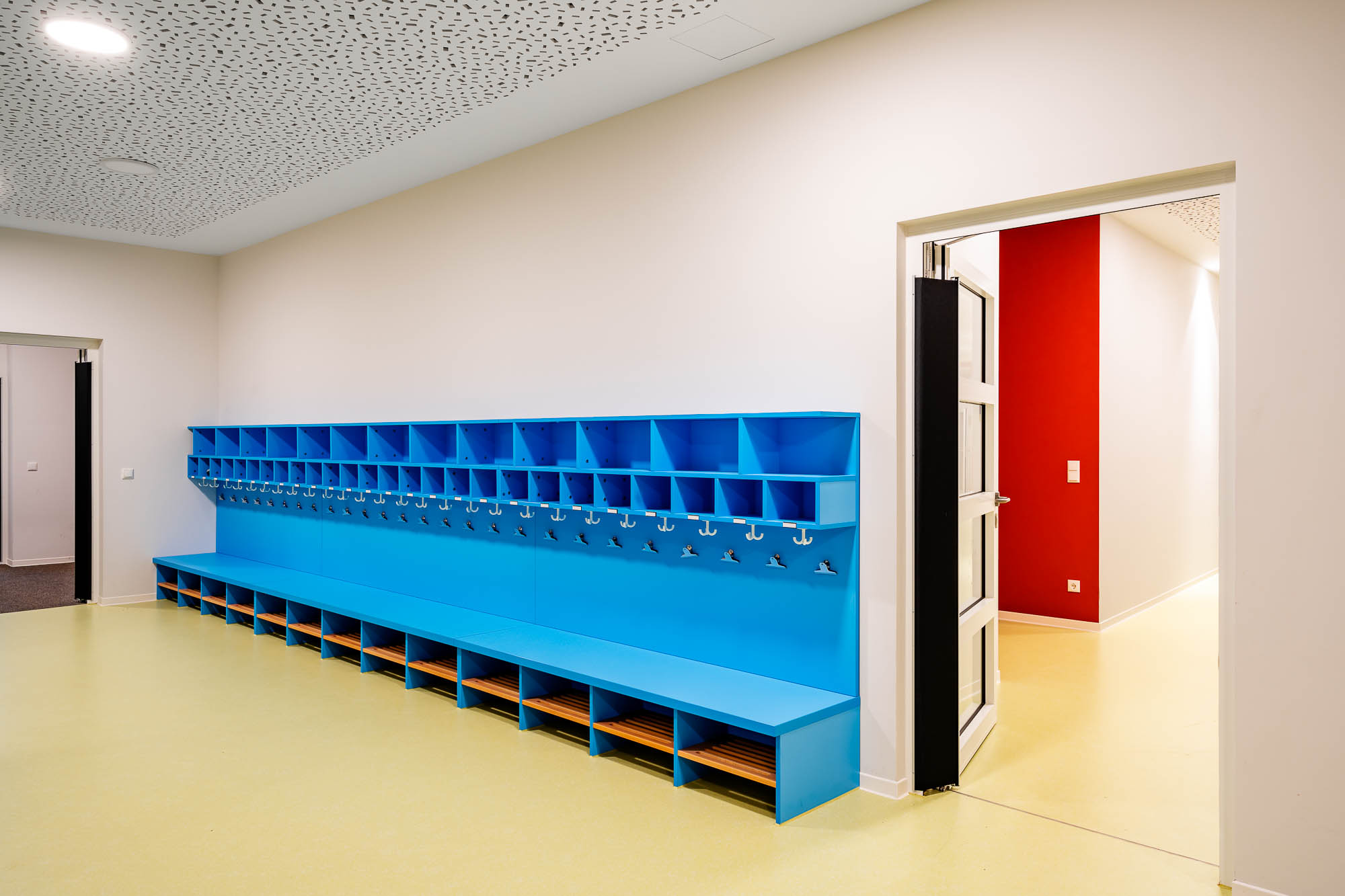 Garderobenflur mit blauer Sitzbank und Haken