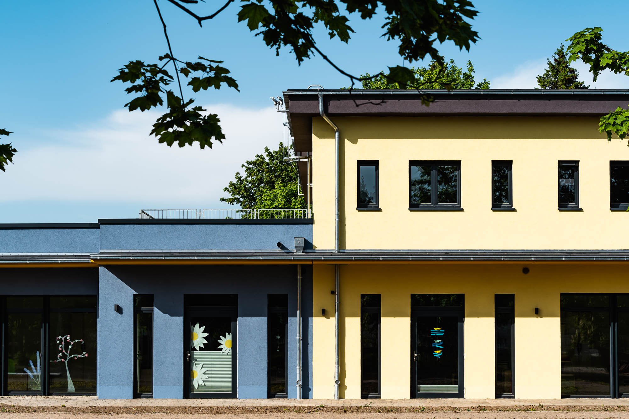 Kita mit gelber Fassade und überdachtem Eingang
