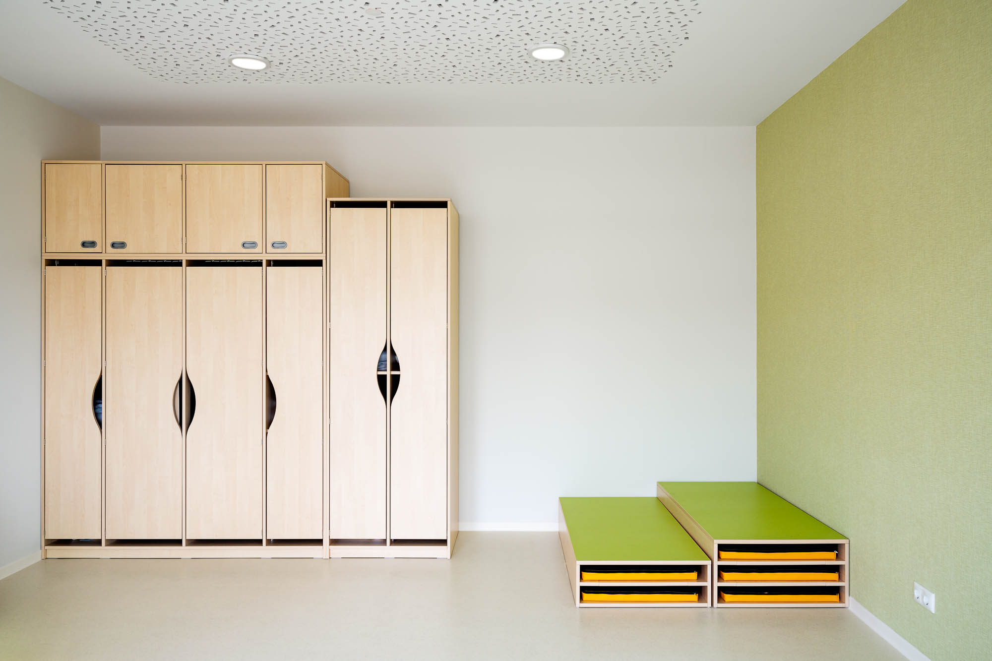 Garderobenbereich der Kita mit Holzschränken und Sitzbank