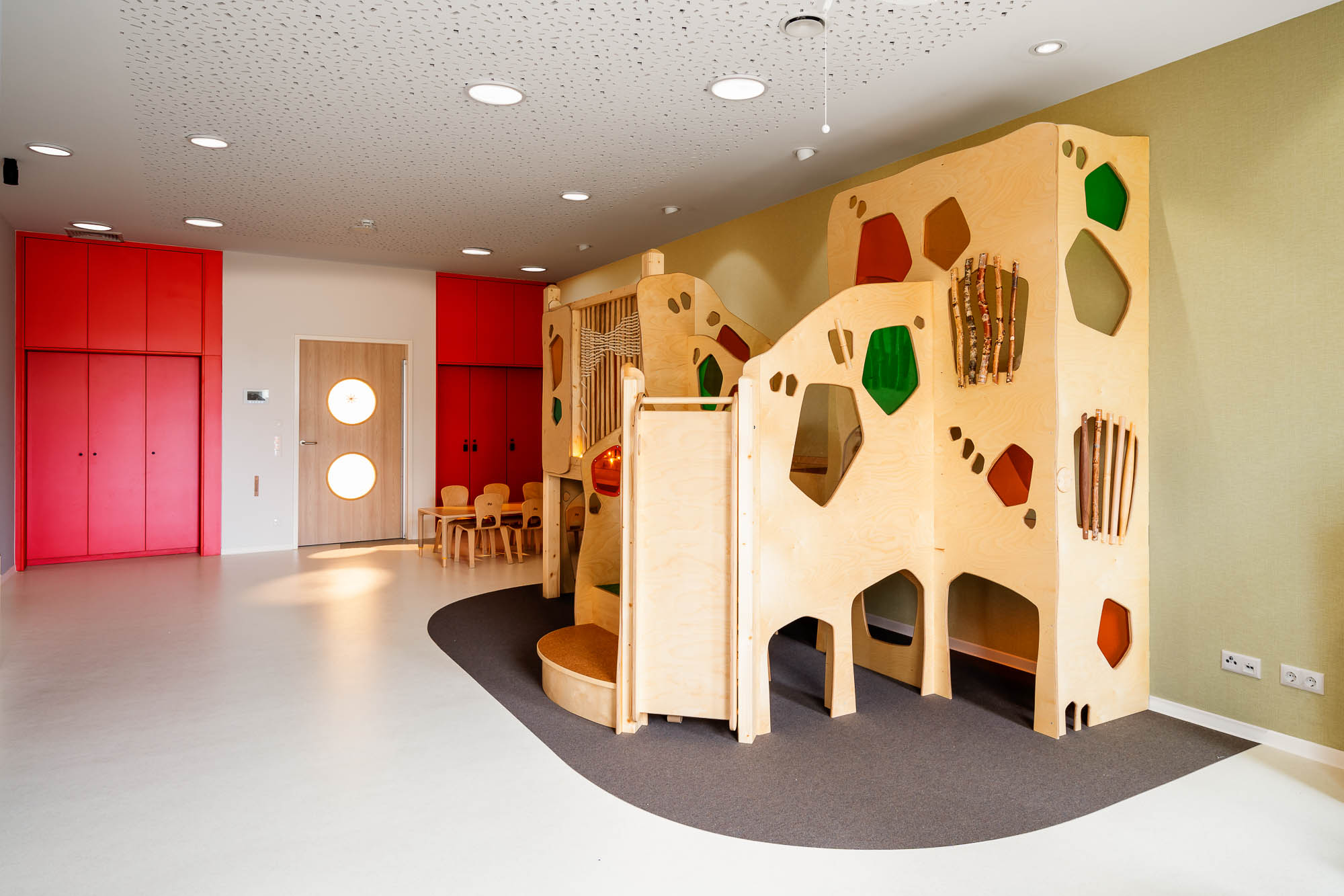 Spielbereich mit Holzelementen und Kletterwand