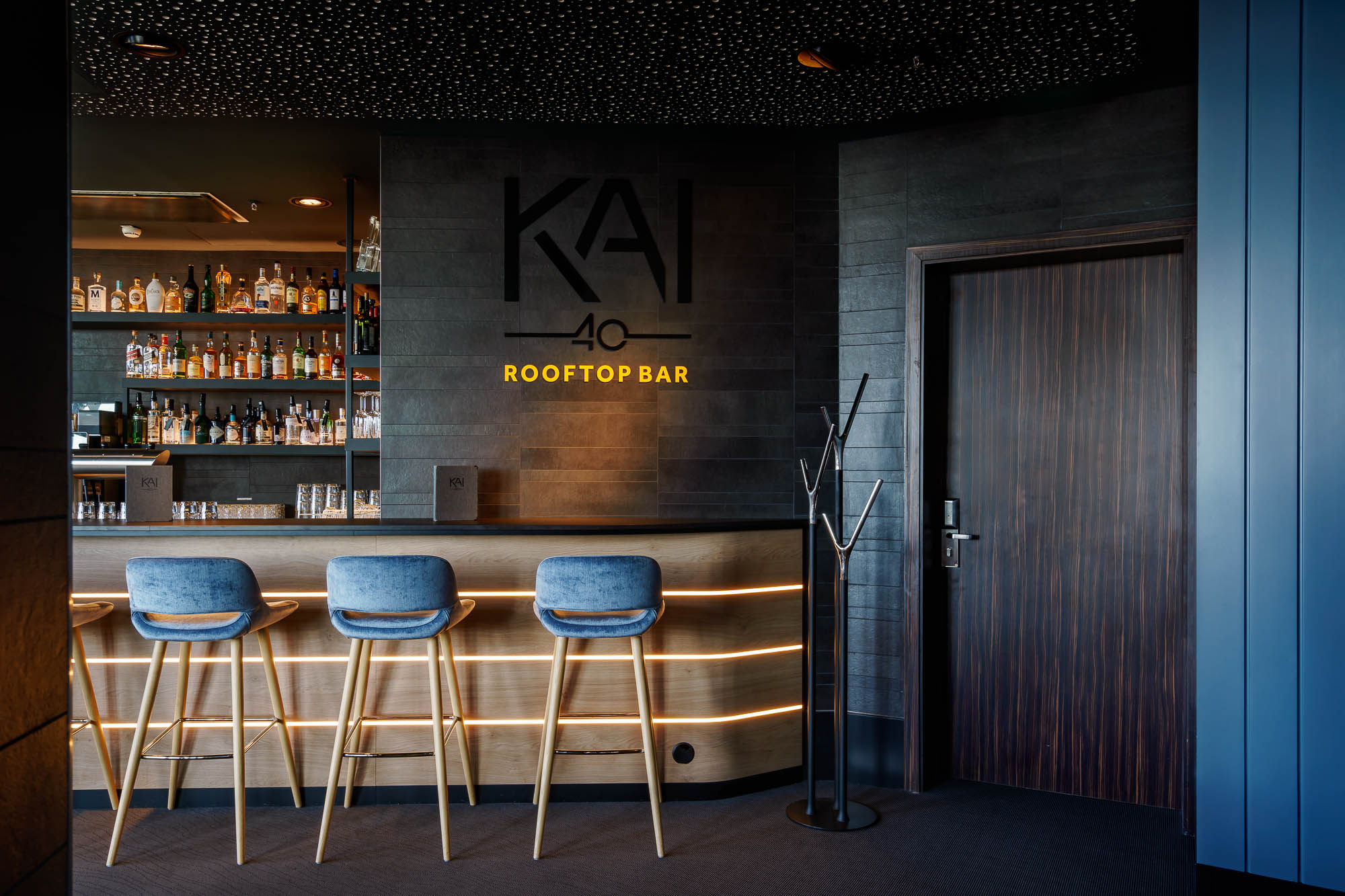 Barbereich der KAI 40 mit Holztheke und blauen Hockern
