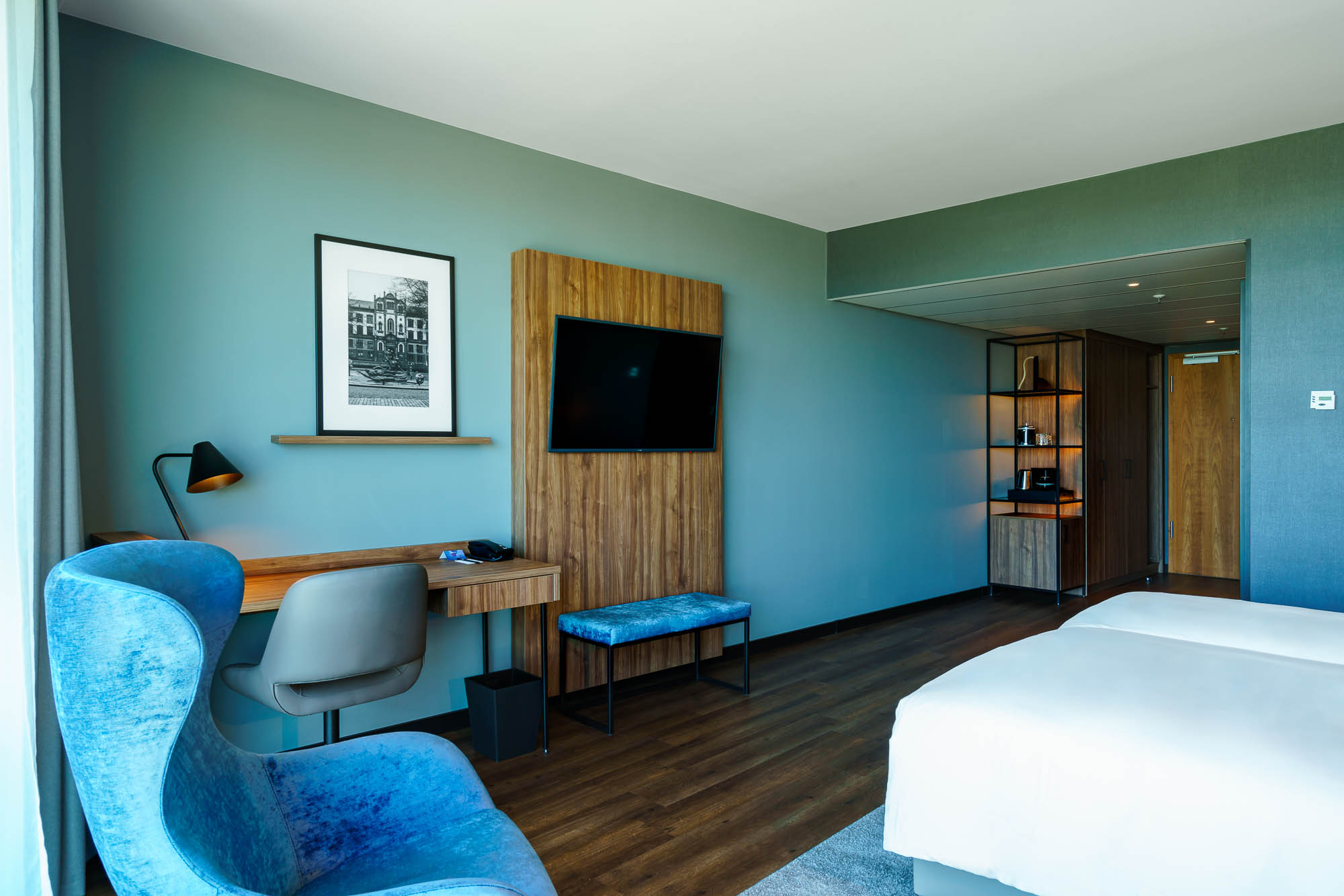Helles Hotelzimmer mit Schreibtisch und Bett