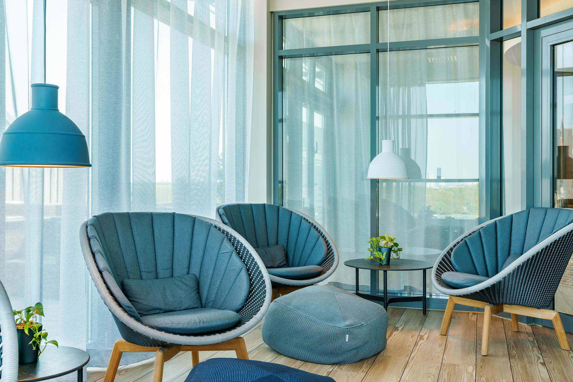 Loungebereich mit blauen Sesseln und Glasfront