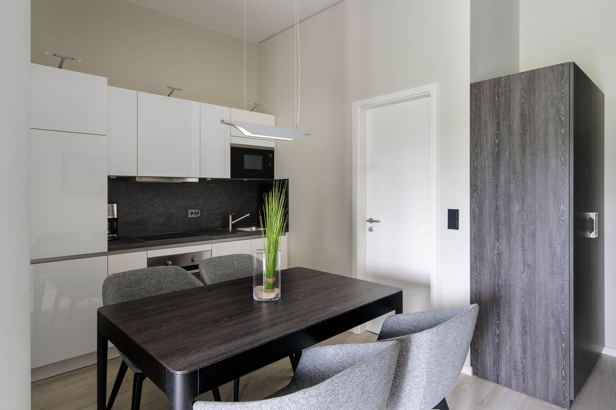 Küchenzeile mit Esstisch und hellen Fronten im Apartmentstil