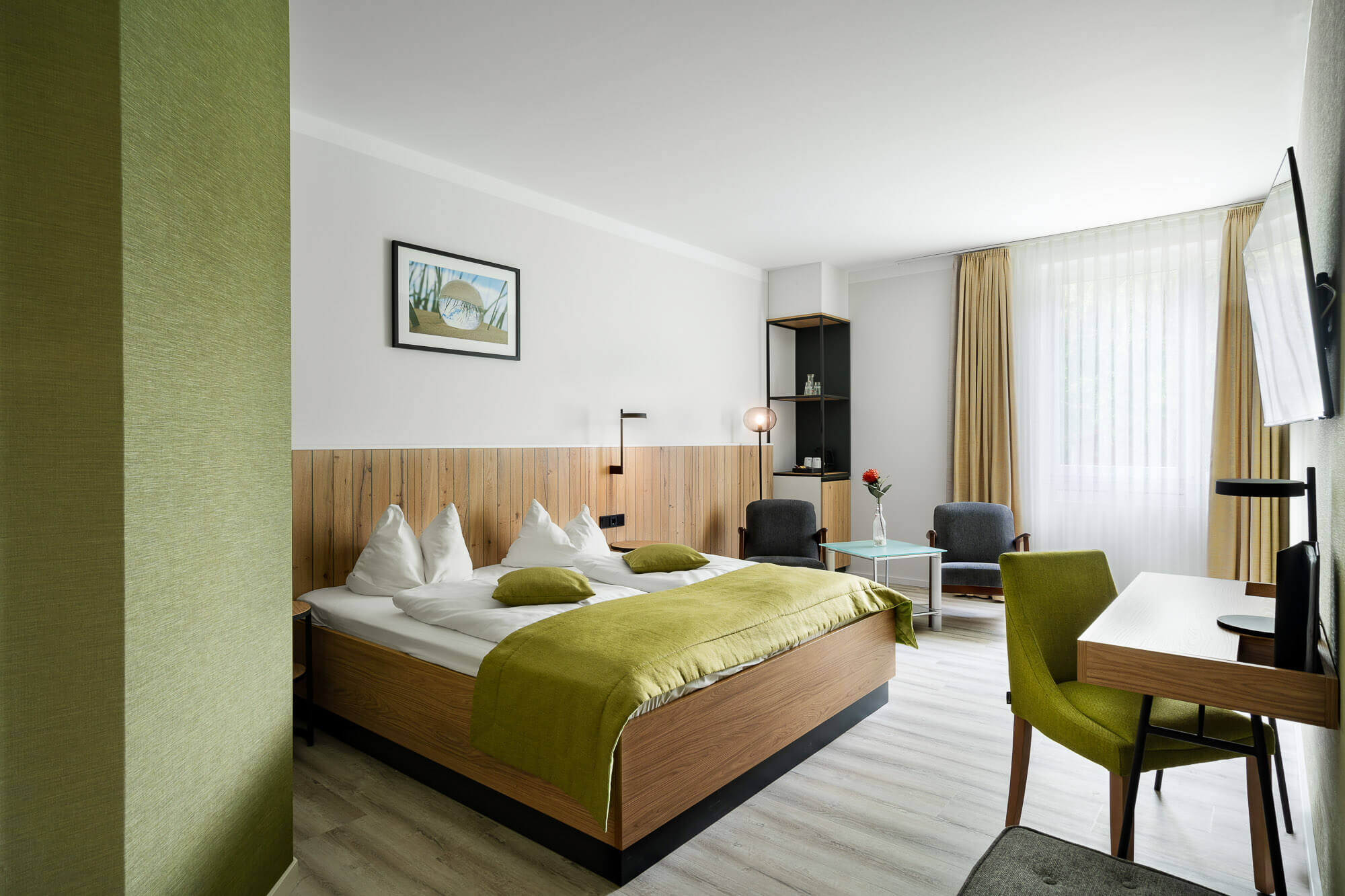 Helles Hotelzimmer mit grünem Wanddesign