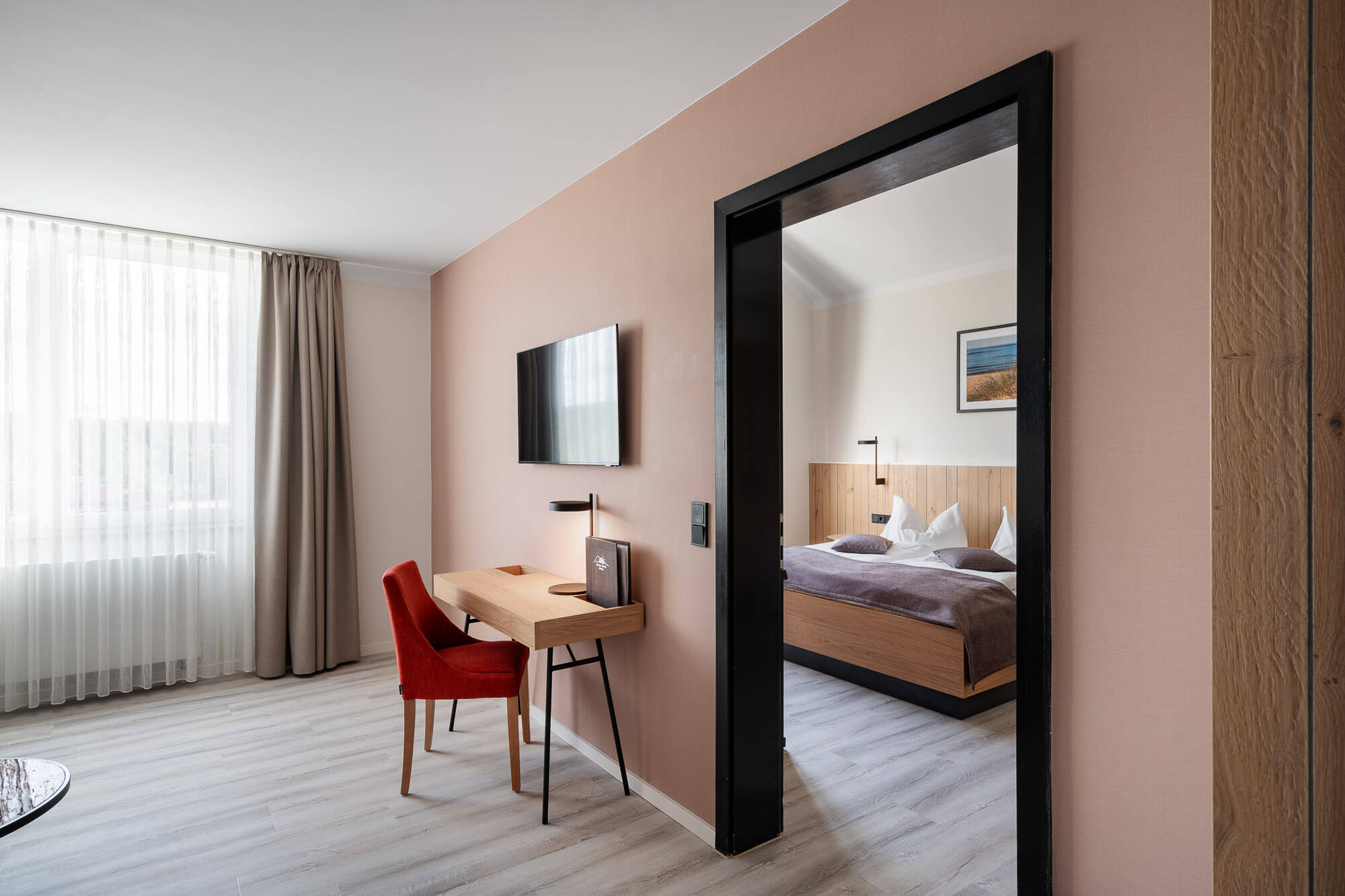 Doppelzimmer mit Schreibtisch und Durchgang zum Wohnbereich