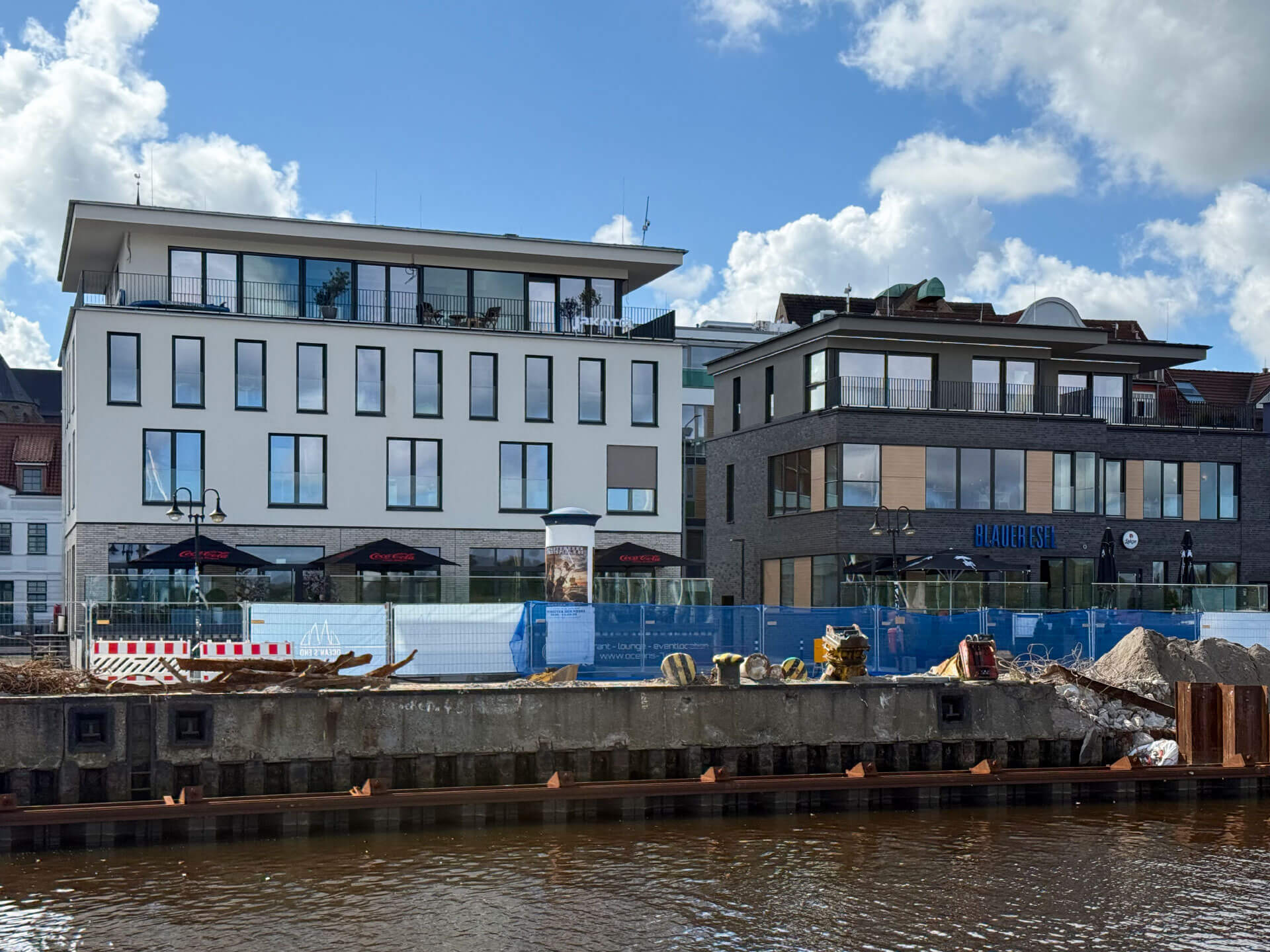 Gebäudeensemble am Wasser mit maritimer Fassade